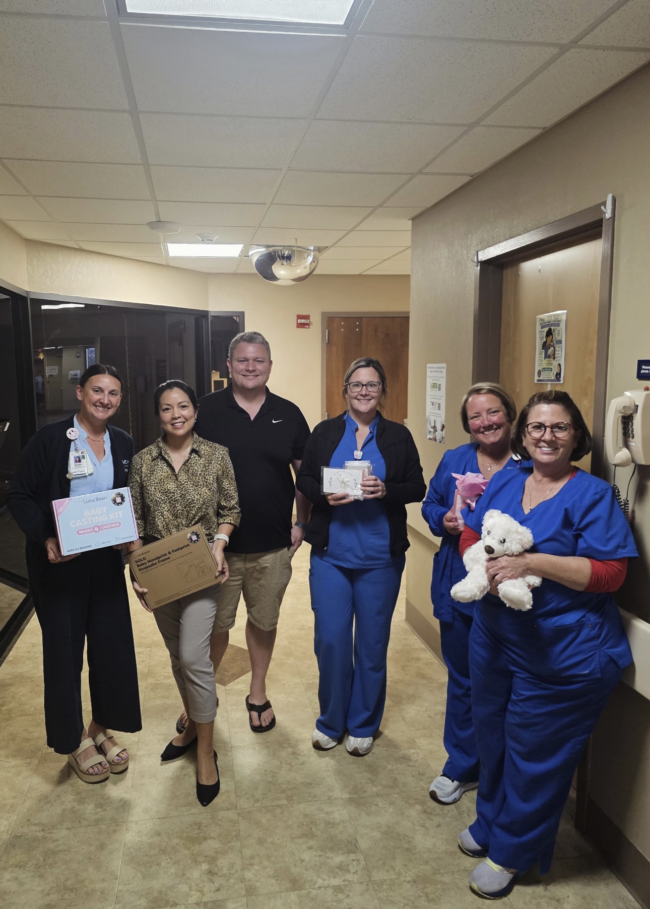 McKenzie's Rays of Sunshine volunteers with NICU staff, holding memory-making kit items